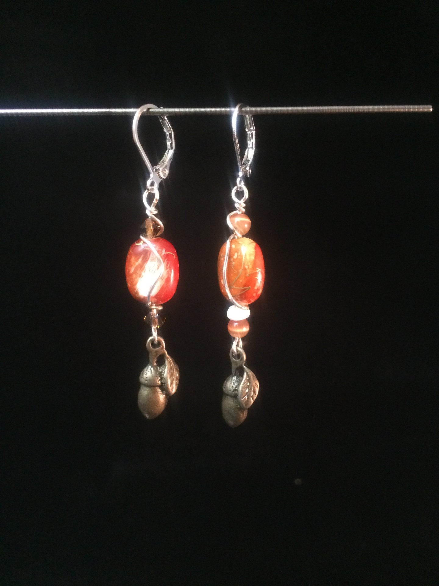 Leverback earrings made from glass beads and metal acorn charms.