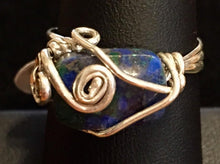 Load image into Gallery viewer, Sterling silver wire swirls over and around a natural 10x6mm chrysocolla bead in this delicately designed ring. Rings made by this wire wrapping method vary individually. This one is approxmately a size 7.5, but may fit a slightly larger finger depending on how snug a fit you prefer.