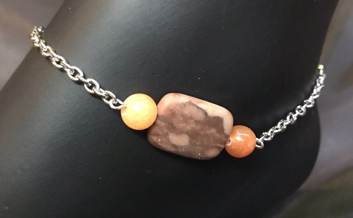 A single strand of agate beads in warm earth tones with a rectangular focal bead accents the stainless steel chain and stainless steel charms on this sturdy, rust-resistant anklet that goes with you on your adventures.