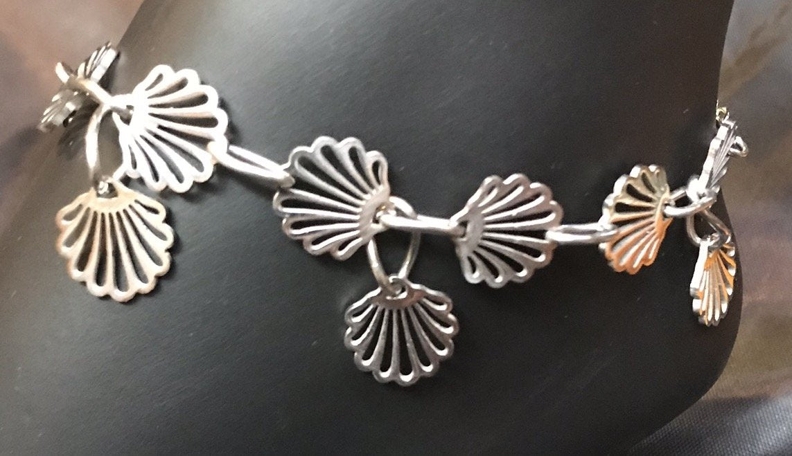 Delicate stainless steel scallop charms form links in the chain in this rust-resistant anklet that can stay with you throughout all your adventures.