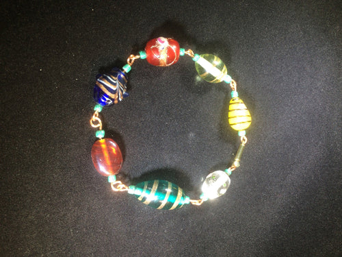 Chunky blown glass beads are linked together with copper wire to form this  8