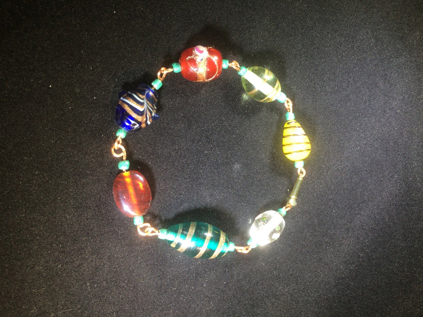 Chunky blown glass beads are linked together with copper wire to form this  8