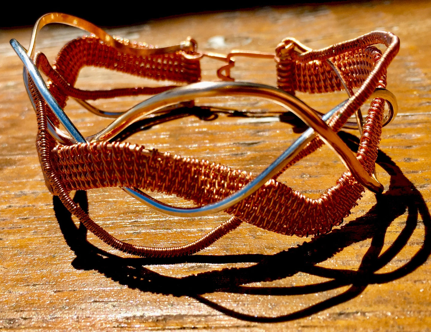 Copper, silver, and bronze wire are woven together and braided in a wavy pattern in this 7.5