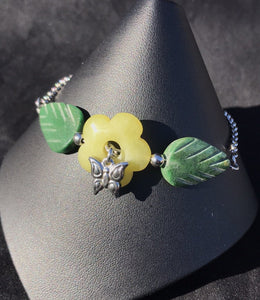 Made from high grade 304 stainless steel, this sturdy corrosion-resistant bracelet features green serpentine beads in the shapes of leaves around an agate flower, accented by a stainless steel butterfly charm.