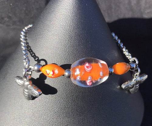 Made from high grade 304 stainless steel, this sturdy corrosion-resistant bracelet features blown glass beads depicting flowers, accented by stainless steel bumblebee charms surrounding the beads.