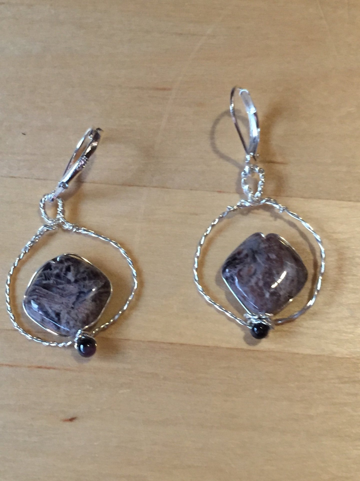 A 12mm diamond-shaped rutilated quartz bead floats inside a fine silver twisted wire circle, accented with a natural tourmaline gemstone bead at the bottom. The earring pendants are mounted on 925-stamped sterling silver leverbacks.