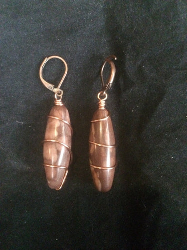 A pair of 30x10mm cavatelli-shaped agate beads is wrapped in copper wire in a spiral pattern, then set onto copper plated brass leverbacks. These earrings are designed to be a matching set with necklace (Spiral Cavatelli Copper Wire Wrapped Agate Necklace - SKU 1NCK0010)