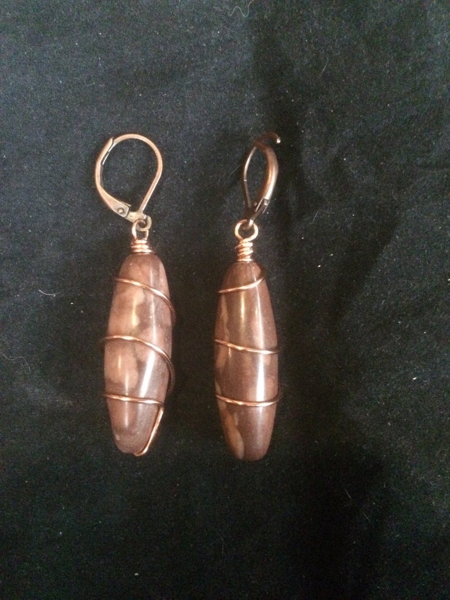 A pair of 30x10mm cavatelli-shaped agate beads is wrapped in copper wire in a spiral pattern, then set onto copper plated brass leverbacks. These earrings are designed to be a matching set with necklace (Spiral Cavatelli Copper Wire Wrapped Agate Necklace - SKU 1NCK0010)