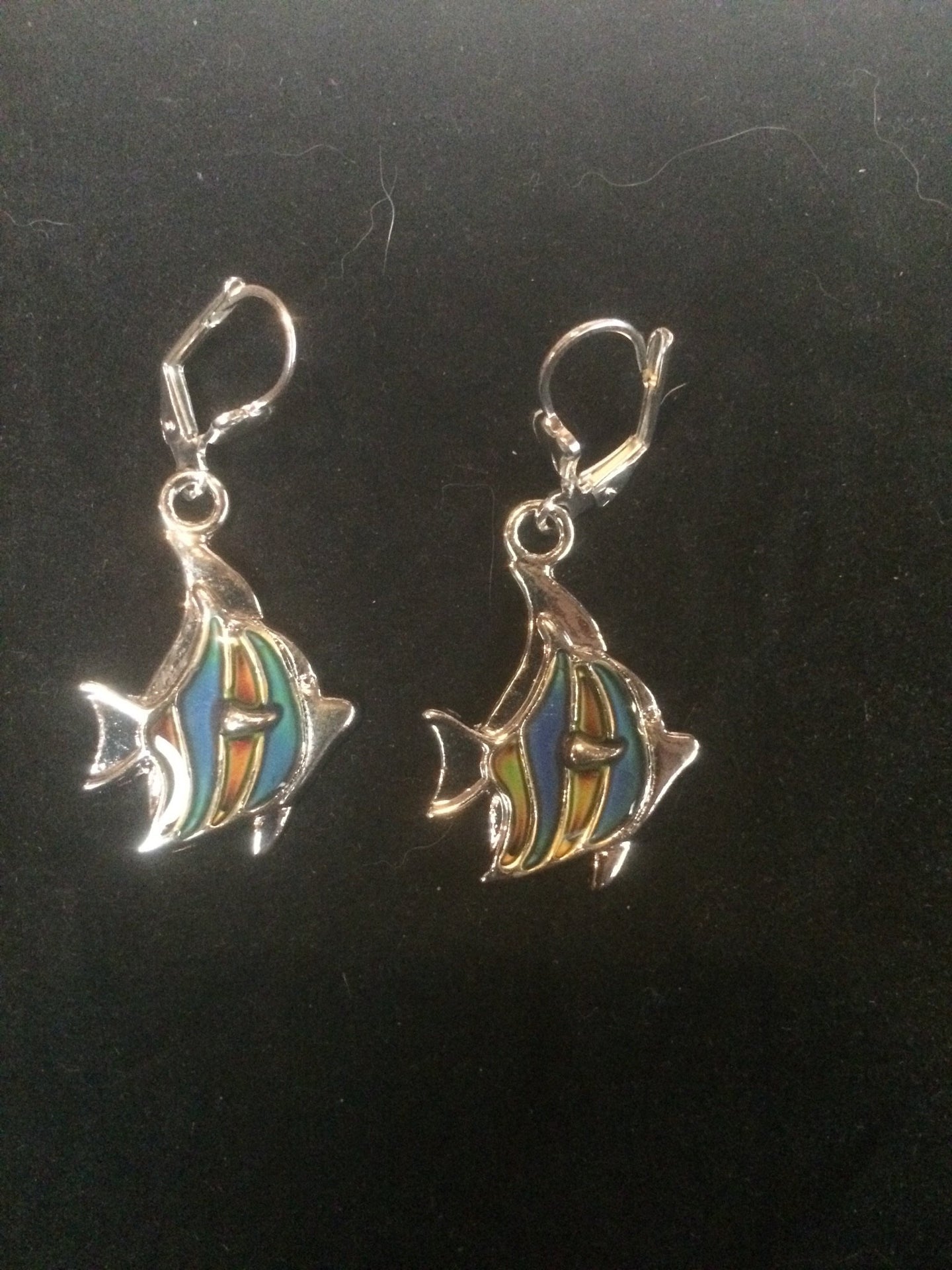 A pair of silver plated fish beads that change color with temperature sits below silver plated brass leverbacks.