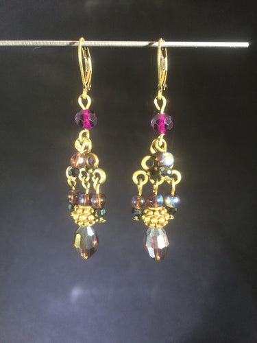 This pair of layered chandelier leverbackåÊearrings is made with a mixture of metal beads, glass peals, and faceted Czech crystal beads, set on plated zinc pewter chandeliers.