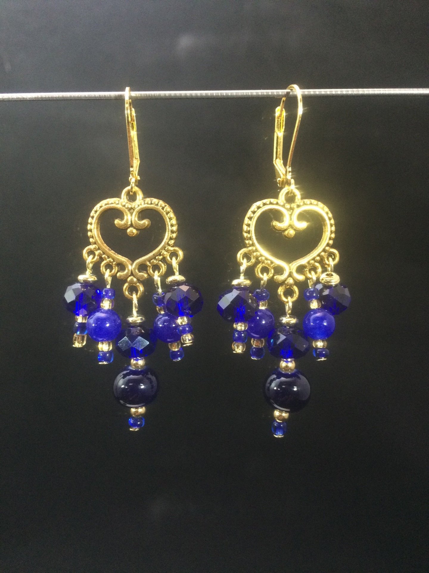 These chandelier-styleåÊleverbackåÊearrings featureåÊa heart-shaped, plated base metalåÊcentral focal, withåÊa mixture of blue faceted glass beads and colored glass pearls.