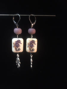 Leverback earrings made from plated metal charms and ceramic beads in a purple tone.