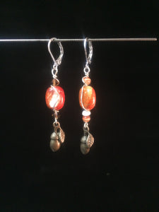 Leverback earrings made from glass beads and metal acorn charms.