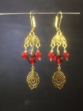 Load image into Gallery viewer, Leverback chandelier earrings adorned with red glass beads and a metal feather charm.
