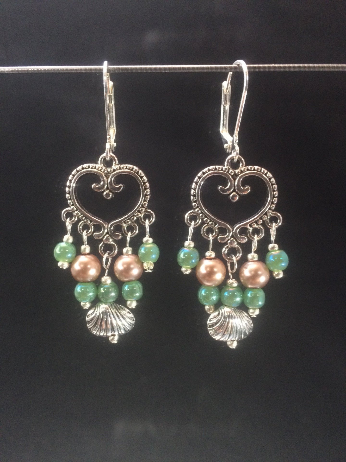 Leverback chandelier earrings made with glass pearls, metal beads, and metal shell charms.