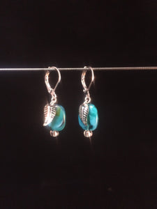 Leverback earrings made with blue blown glass beads with swirls and metal leaf charms.åÊ The plated metal leafs and leverback findings come in three available tones; a dark tone, lighter silvery tone or a goldish tone.