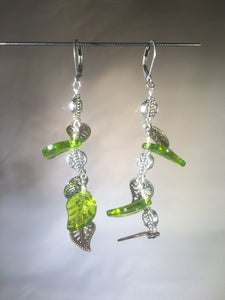 A mixture of vivid green Czech pressed glass leaves and metal leaf charms and beads dangle to the side on these 2" drop jointed silver plated brass leverback earrings.