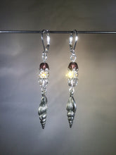 Load image into Gallery viewer, Leverback earrings with metal conch charms, red colored and faceted glass beads, and a faceted crystal cluster.