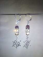 Load image into Gallery viewer, Leverback earrings with metal ship&#39;s wheel charms, purple colored and faceted glass beads, and a faceted crystal cluster.