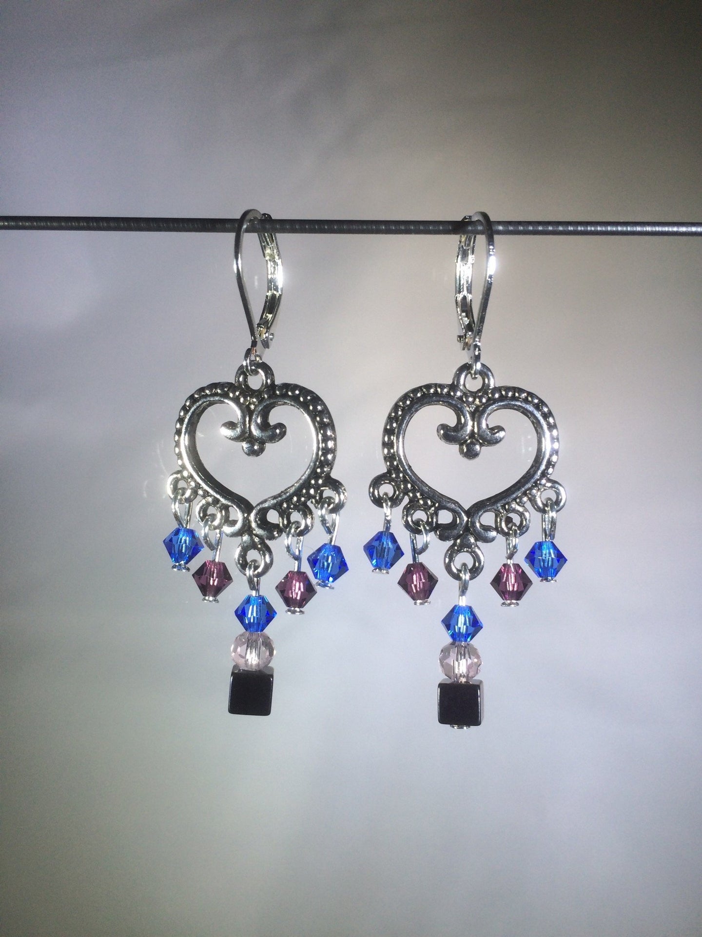 Blue glass and Czech crystal beads dangle from a central brass heart focal in these 1.25