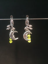 Load image into Gallery viewer, A silver plated moon charm is adorned with natural peridot beads, then set on silver plated brass leverbacks. These earrings form a matching set with necklace 1NCK0053.