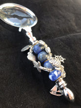 Load image into Gallery viewer, An anchor charm dangles over sea life charms and dazzling blue cut and blown glass beads on the handle of this magnifying glass.