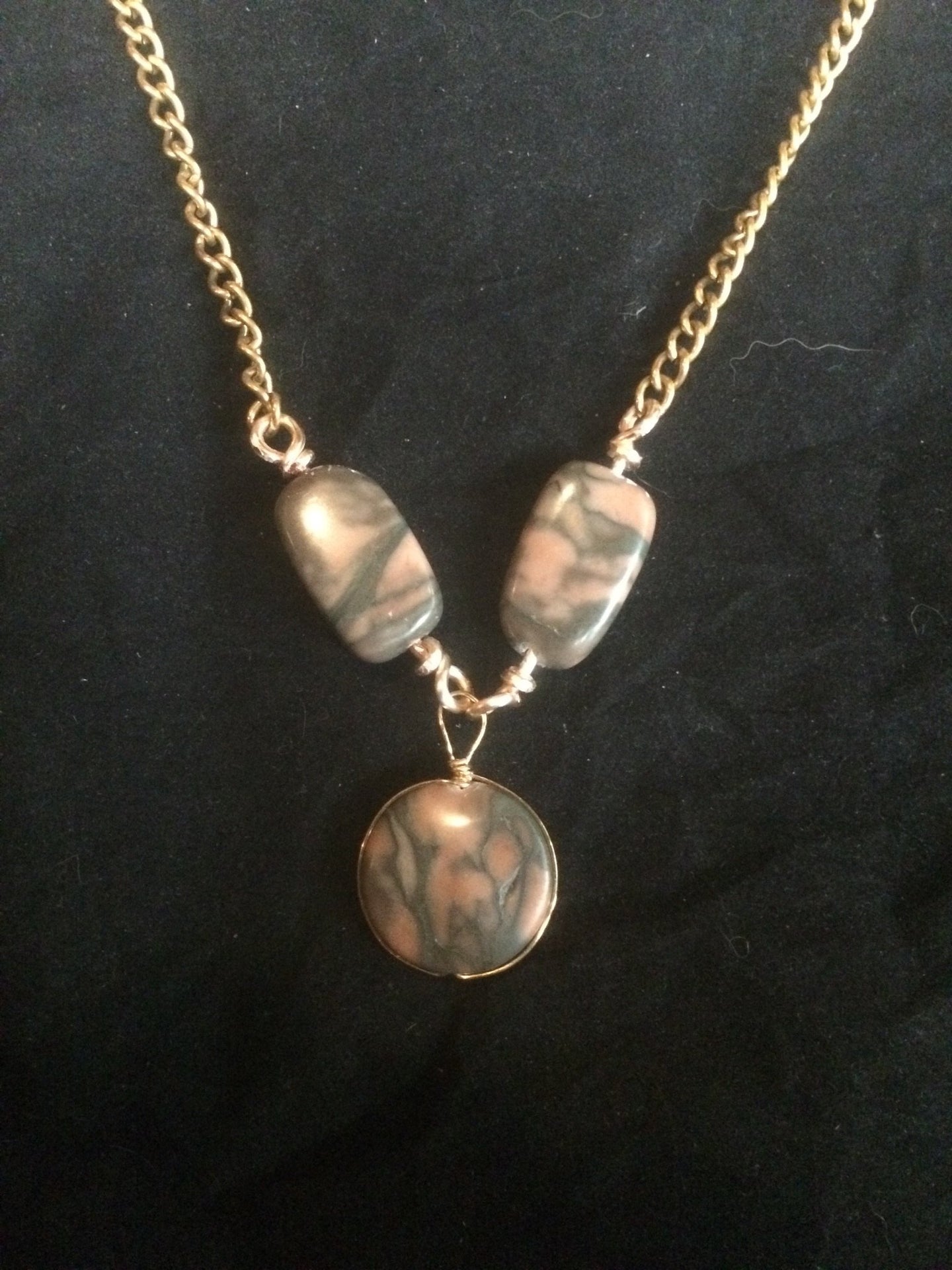 A pair of 20x11mm rectangular agate beads flanks a central 19mm agate disk bead encased in plated copper wire. The 24