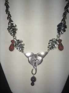 A necklace made from plated metal charms, faceted glass beads, and round glass pearls.
