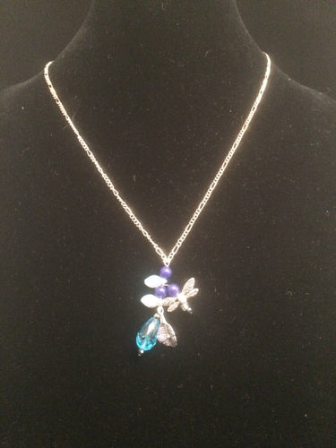 Necklace set with a lily theme accented with blue glass beads and blue faceted beads and metal charms. Forms a matching set when purchased with earrings 1EAR0136.