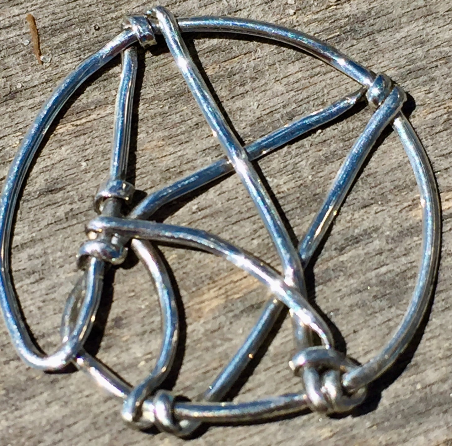 The logo for Atheist Alliance International is depicted in sterling silver in this wire wrap pendant, set onto a 16