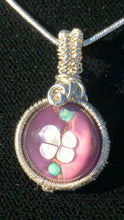 Load image into Gallery viewer, A purple 14mm blown glass cabochon depicting an apple blossom is woven into a fine silver pendant, then set on a 20&quot; sterling silver chain.