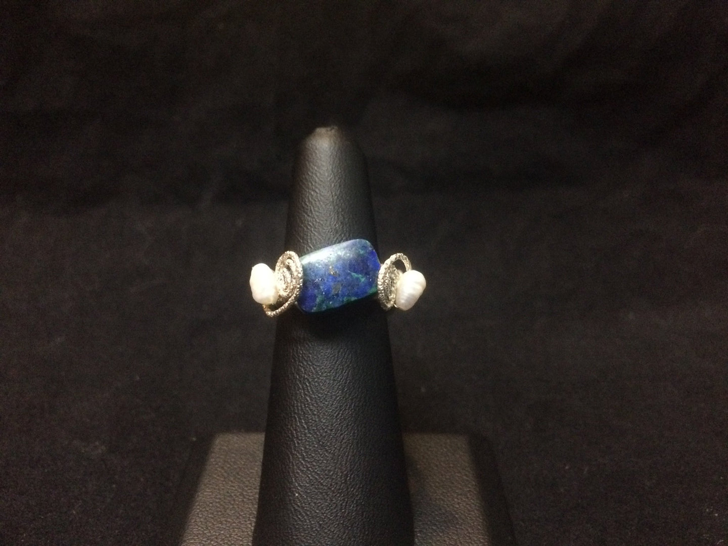 A 12x8mm natural chrysocolla bead is set with two textured swirls and two freshwater seed pearls as accents in this sterling silver wire wrapped ring. The wire wrapped rings made via this method vary individually. This one is approximately a size 6.5.