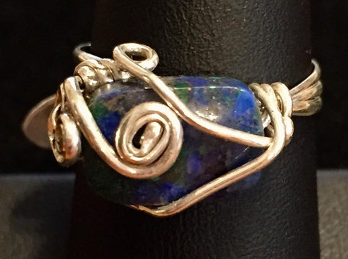 Sterling silver wire swirls over and around a natural 10x6mm chrysocolla bead in this delicately designed ring. Rings made by this wire wrapping method vary individually. This one is approxmately a size 7.5, but may fit a slightly larger finger depending on how snug a fit you prefer.